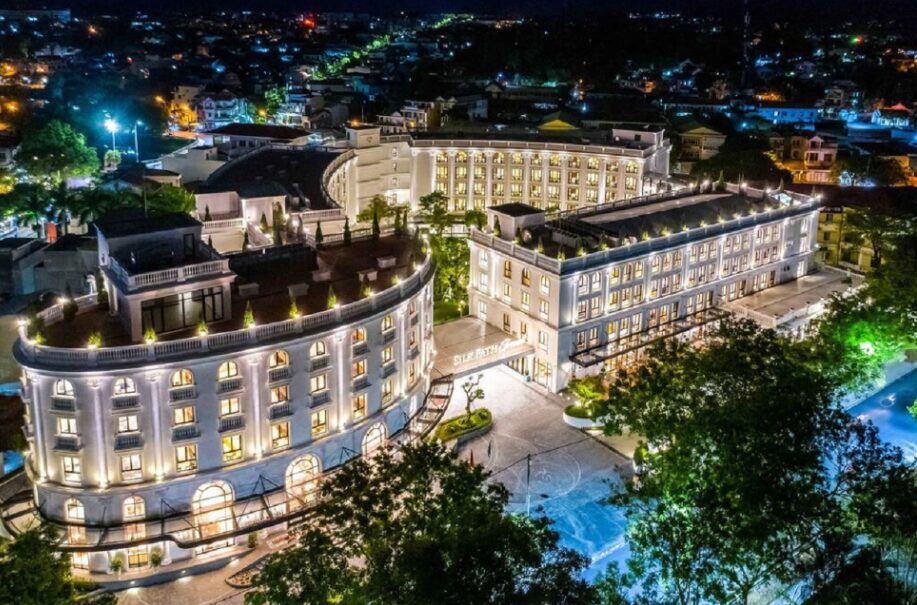 Night aerial view of silk path grand hue hotel glowing with lights in central Hue Vietnam.