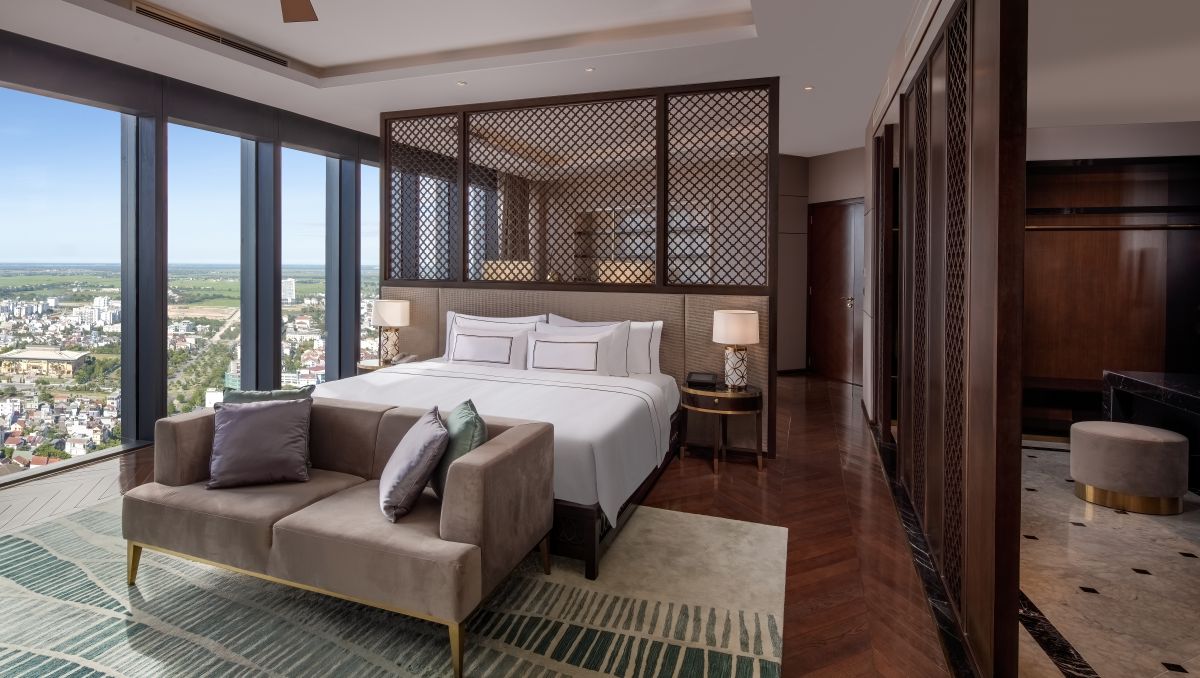 Spacious suite at Melia Vinpearl Hue featuring king-size bed, floor-to-ceiling windows, and sweeping views of Hue’s ancient city.