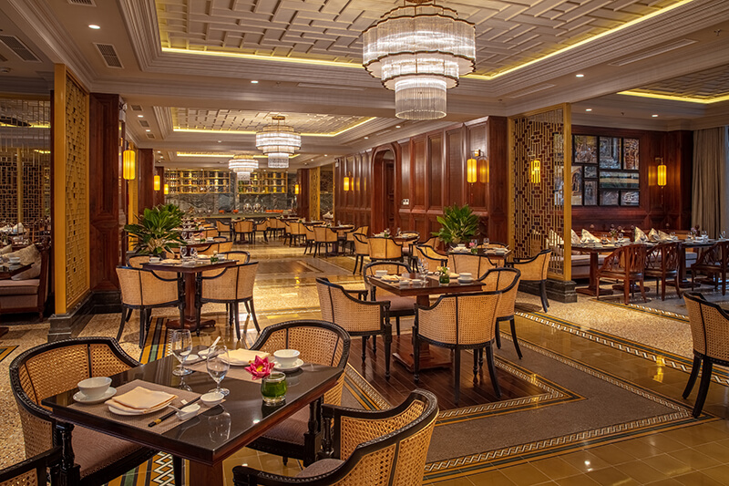 Luxury restaurant interior at silk path grand hue hotel featuring chandeliers, warm lights, and elegant design.