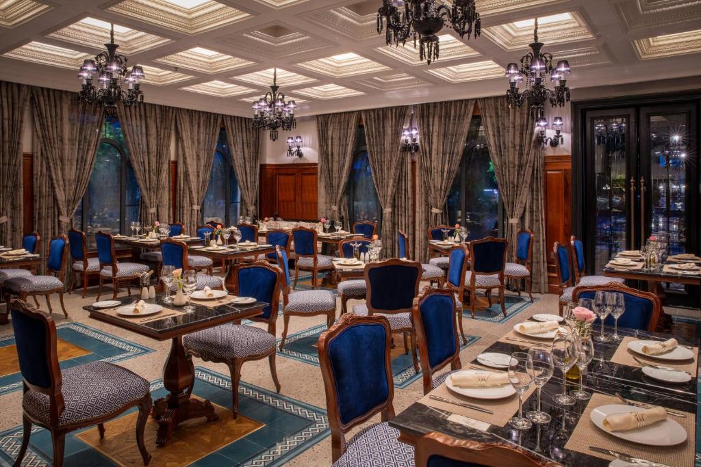 Fine dining restaurant at silk path grand hue hotel with blue chairs and classic European decor.