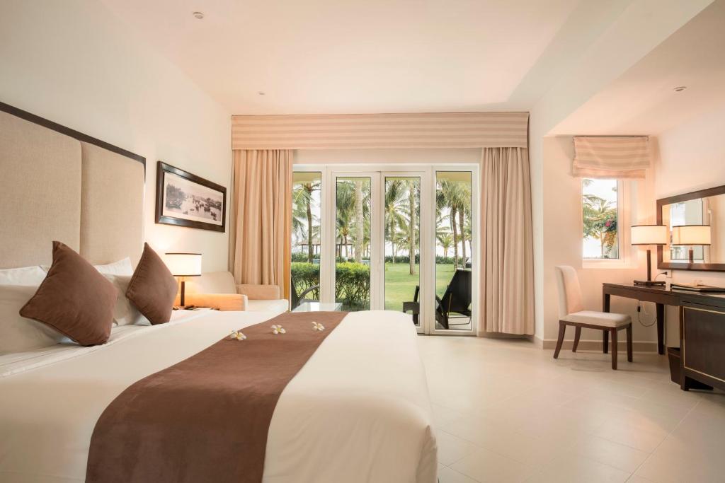 Bright deluxe room with king bed, garden view, and elegant modern décor at Boutique Hoi An Resort.