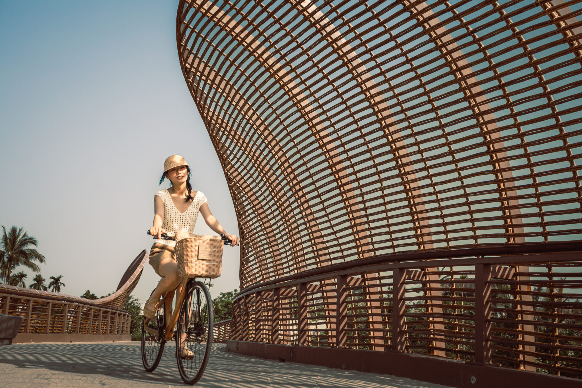 Guest cycling across the iconic bamboo bridge at Namia River Retreat, enjoying nature and eco-friendly exploration.