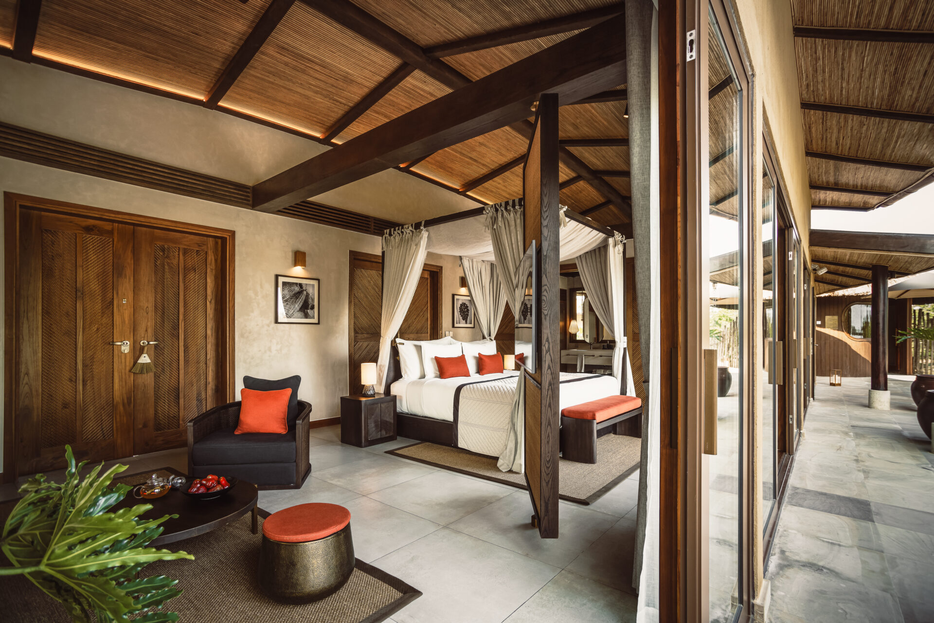 Elegant villa bedroom at Namia River Retreat featuring canopy bed, warm wood design, private terrace, and relaxing tropical ambiance.