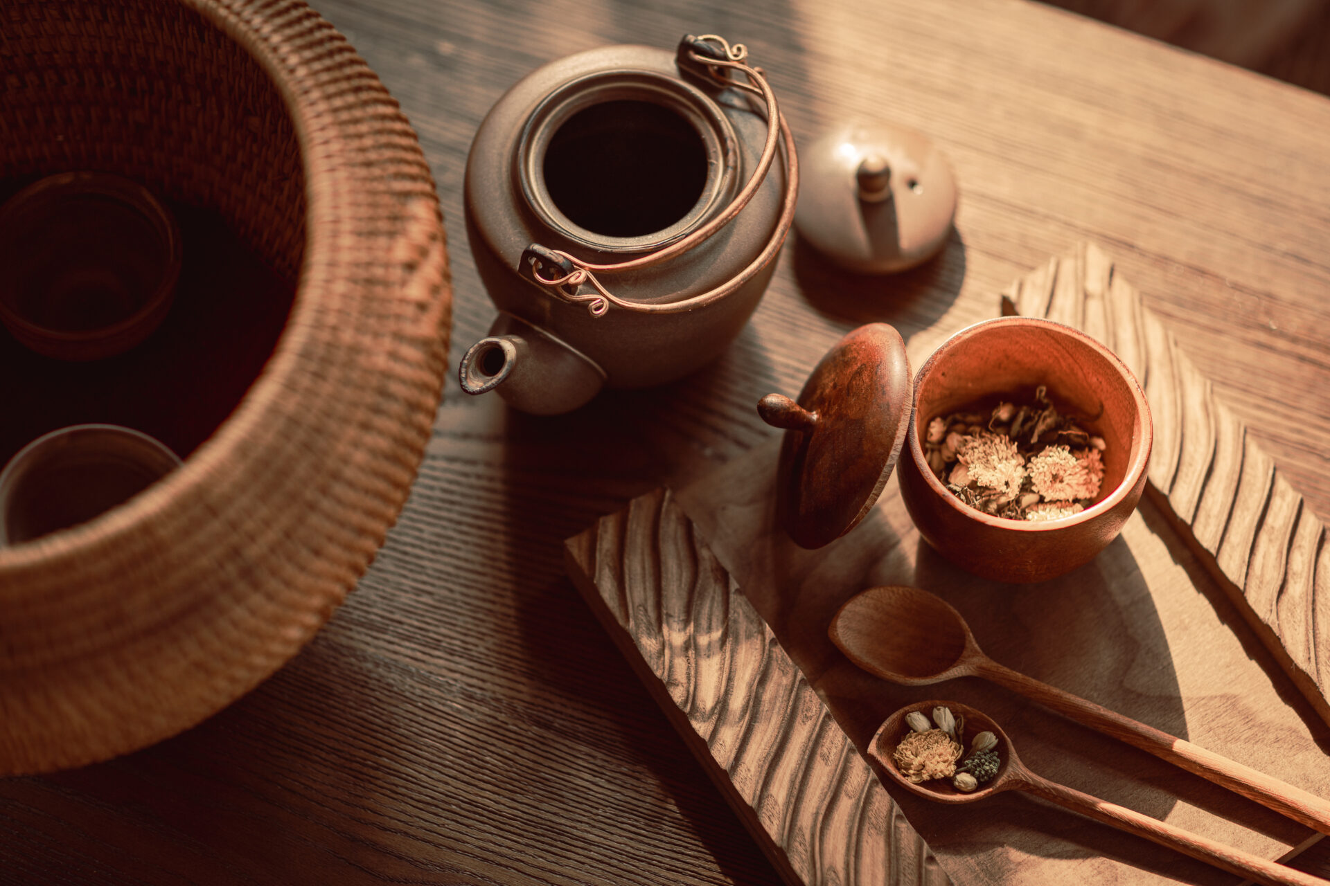 Traditional herbal tea set at Namia River Retreat featuring ceramic teapot, wooden bowl, and natural wellness ingredients on rustic table.