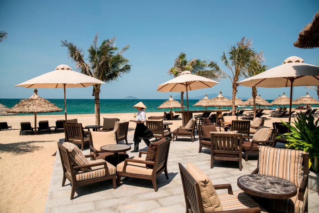 La Plage Beach Bar with oceanfront seating, umbrellas, and tropical drinks at Boutique Hoi An Resort.