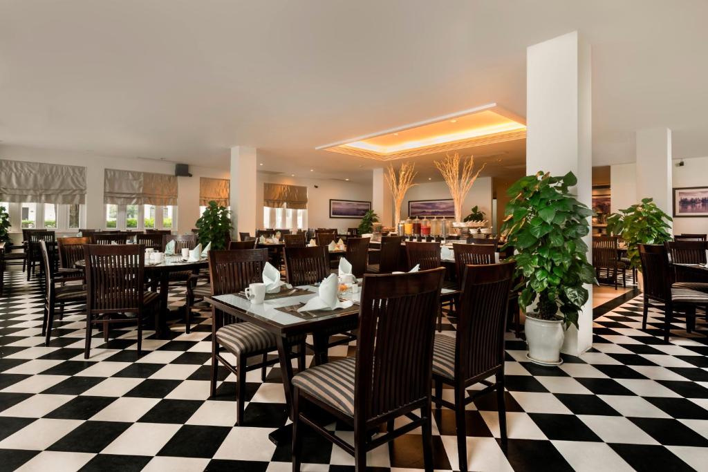 Le Café Restaurant featuring checkered floor, warm lighting, and elegant dining setting at Boutique Hoi An Resort.
