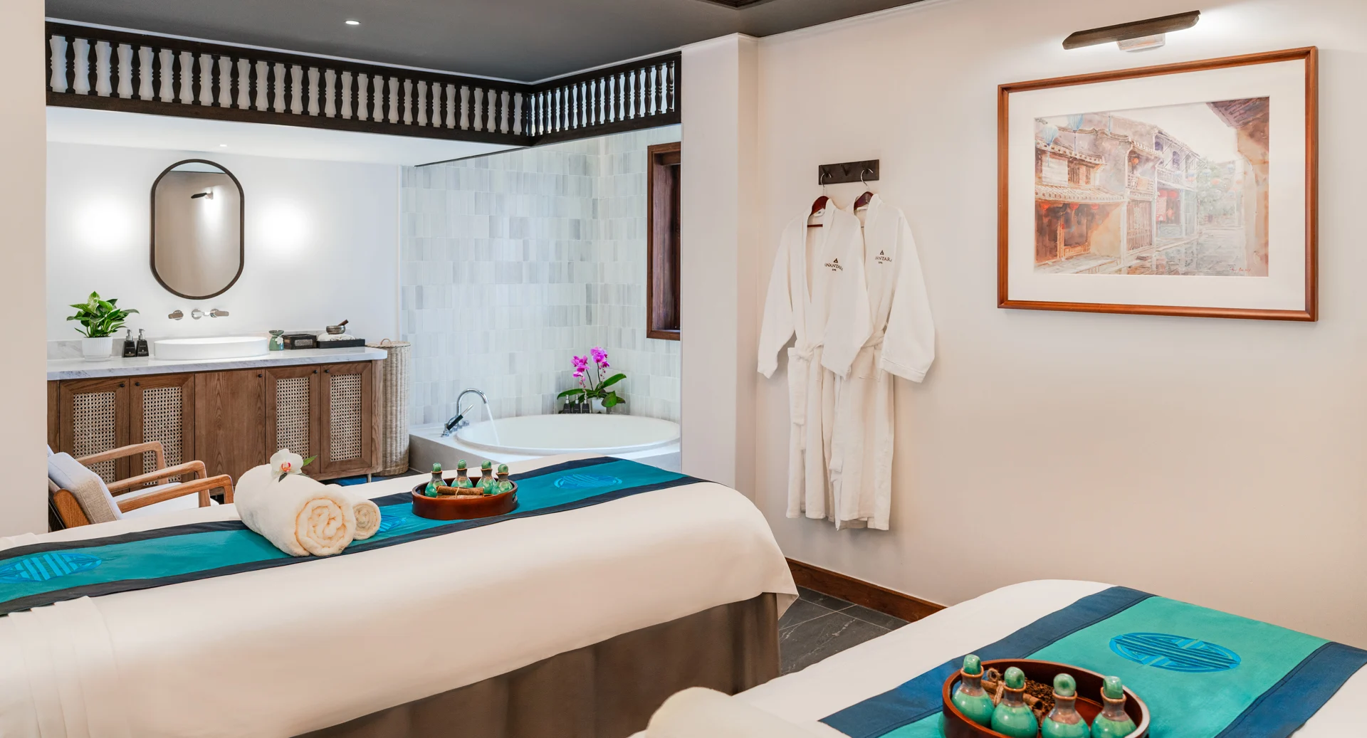 Luxury spa treatment room with twin beds, herbal oils, and a soaking tub at Anantara Hoi An Resort.