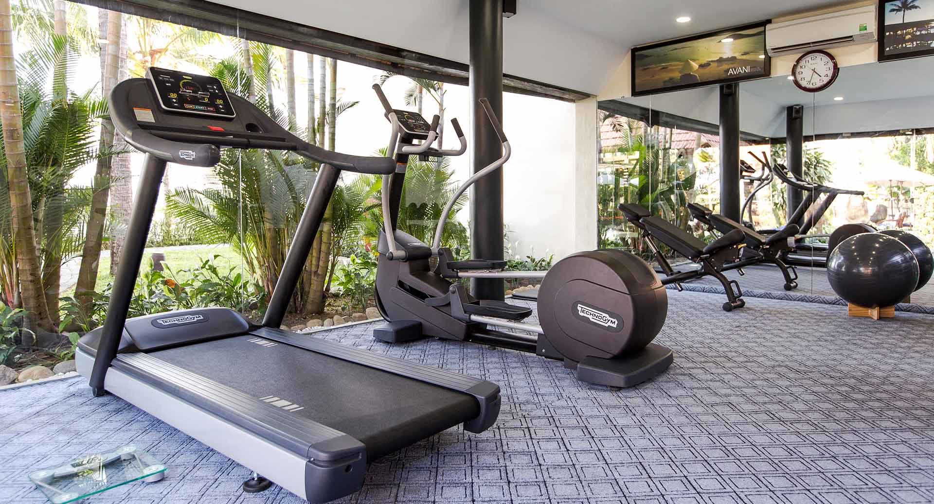 Modern fitness center with Technogym equipment and garden views at Anantara Hoi An Resort Hoi An.