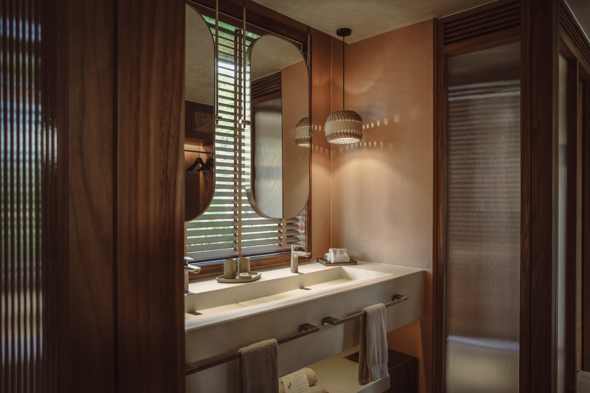 Luxurious bathroom at Namia River Retreat featuring dual sinks, warm lighting, wooden finishes, and elegant spa-inspired décor.
