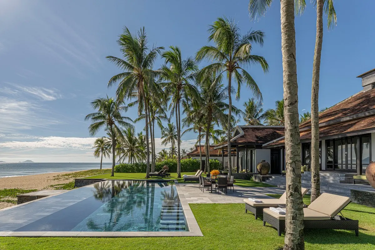 Private beachfront pool villa under palm trees at Four Seasons Resort The Nam Hai, Central Vietnam.