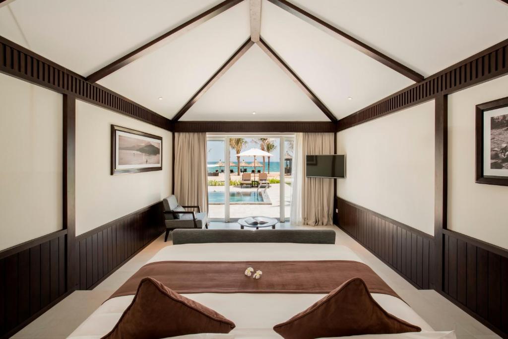 Spacious beachfront suite with high wooden ceiling and sea view at Boutique Hoi An Resort.
