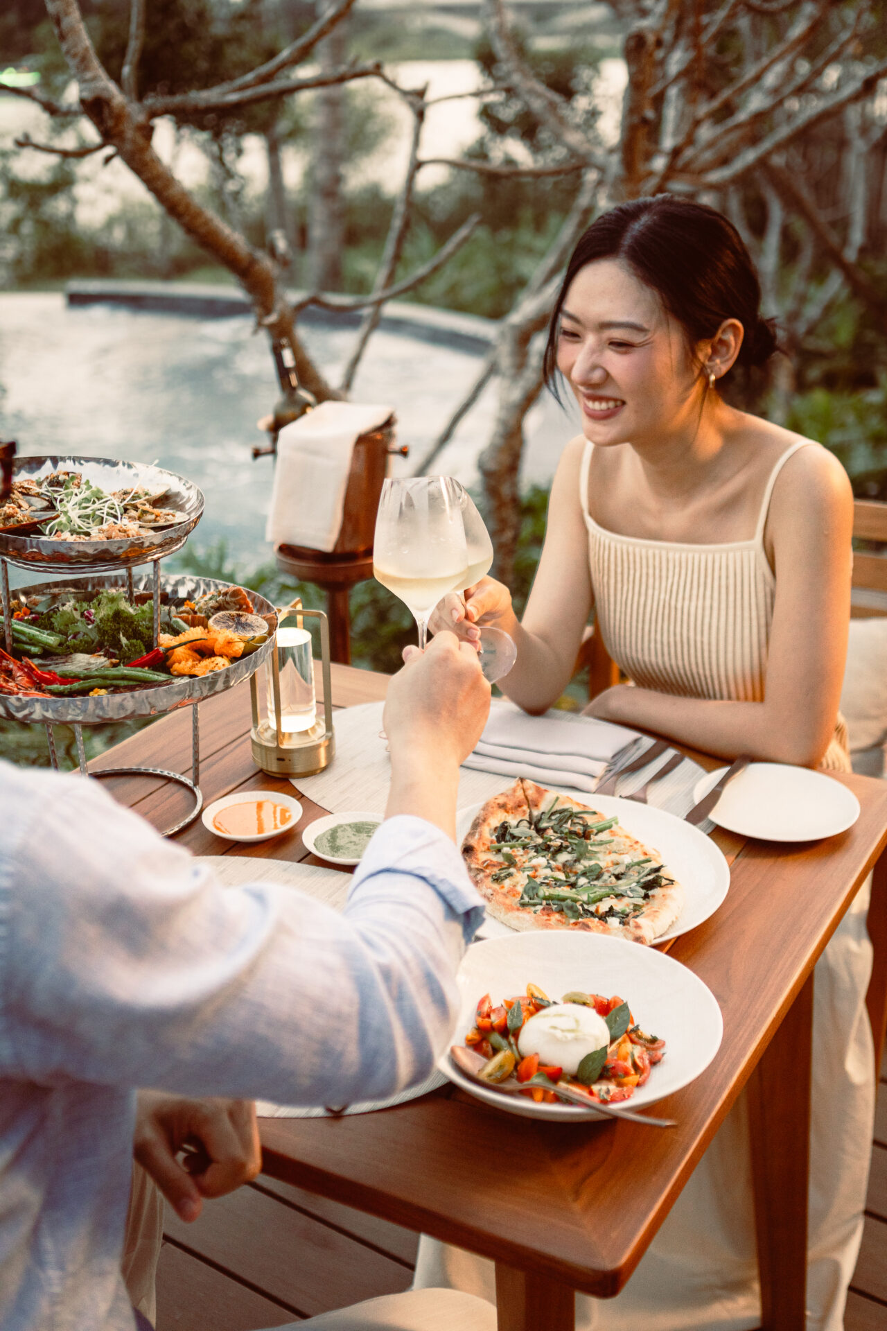 Romantic riverside dinner at Namia River Retreat with gourmet dishes, wine, and sunset views beside the private pool.