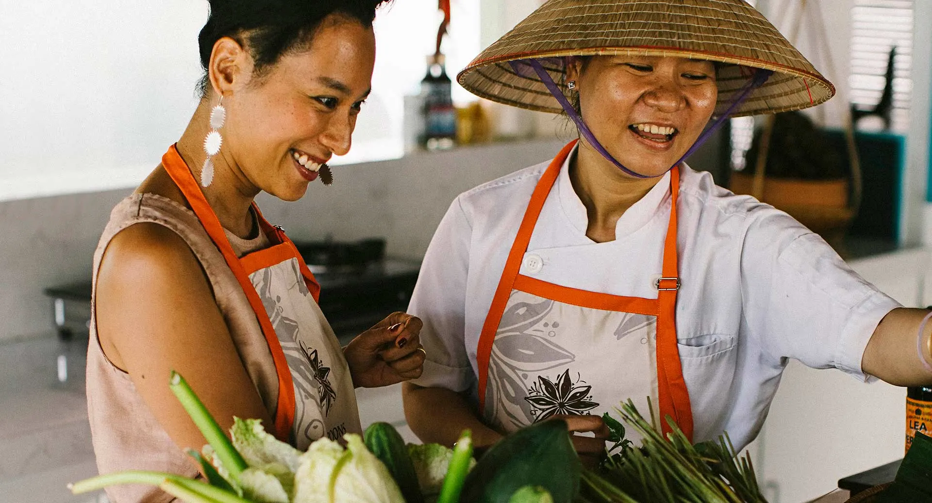 Vietnamese cooking class with guests learning traditional recipes at Anantara Hoi An Resort cooking school.
