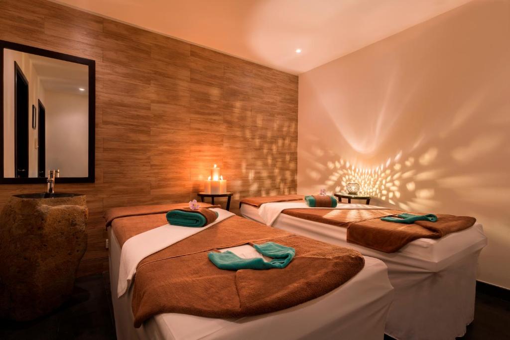 Tranquil spa room with warm lighting and massage beds for relaxation at Boutique Hoi An Resort.