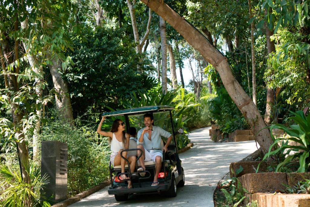 Guests exploring the lush pathways of Six Senses Krabey Island by electric buggy, enjoying a relaxed and immersive island experience. 