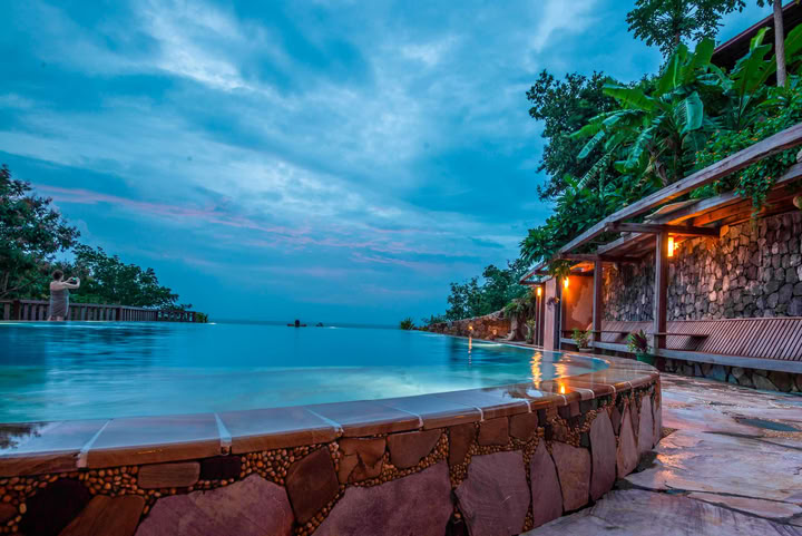 Infinity swimming pool at Veranda Natural Resort appears to spill into the forest valley