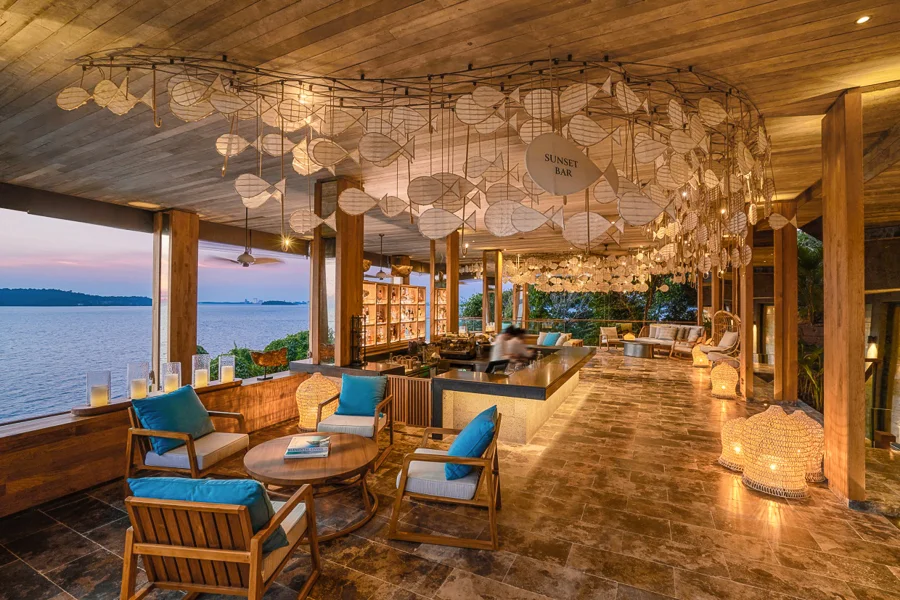 Sunset Bar at Six Senses Krabey Island, offering elegant seating, warm ambient lighting, and panoramic views over the calm ocean at dusk.