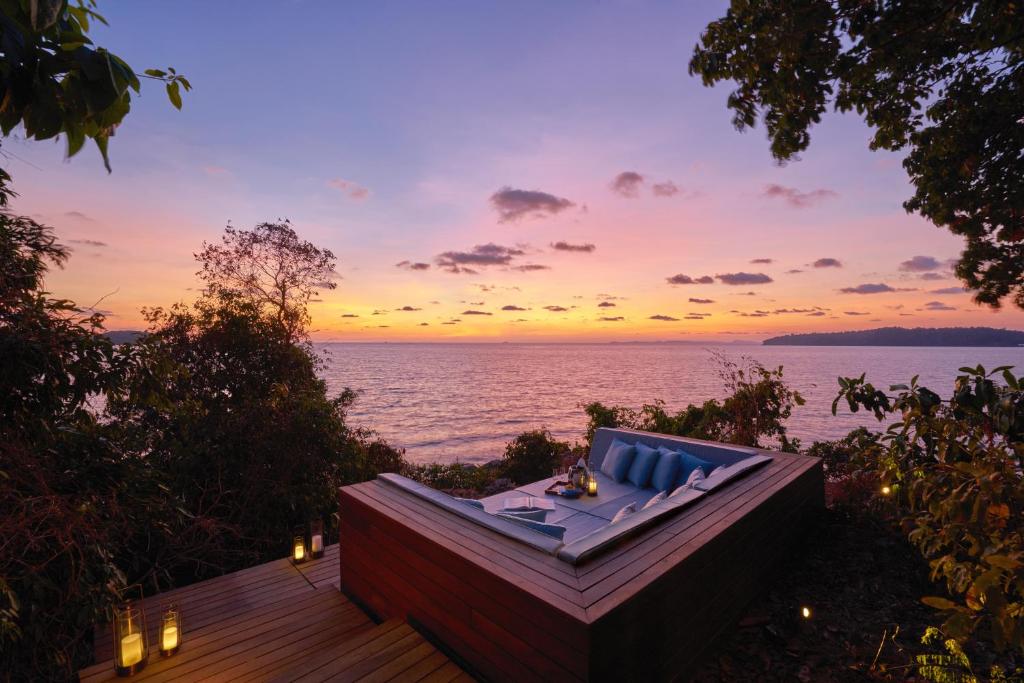 Sunset scenery at Six Senses Krabey Island, with golden light reflecting across tranquil waters and dramatic coastal rock formations.
