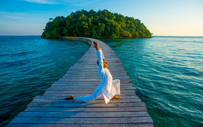 Morning yoga session on the wooden pier at Song Saa Private Island surrounded by turquoise waters