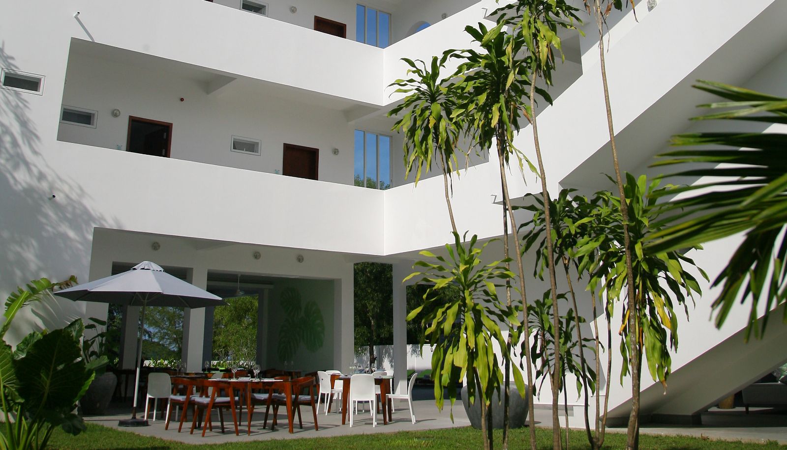 Open courtyard and outdoor dining area at Naia Resort Sihanoukville surrounded by tropical greenery