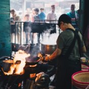 Chef cooking over open flames at Bangkok Street Food MICHELIN Restaurants, showcasing authentic Thai culinary craftsmanship