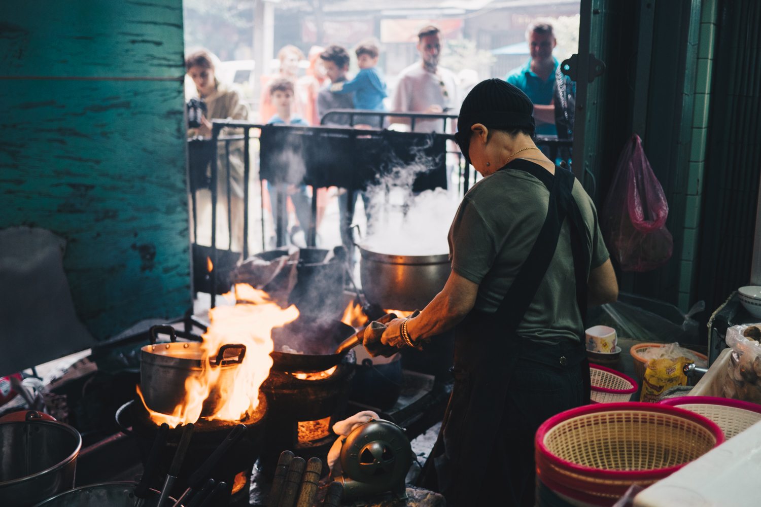 Chef cooking over open flames at Bangkok Street Food MICHELIN Restaurants, showcasing authentic Thai culinary craftsmanship
