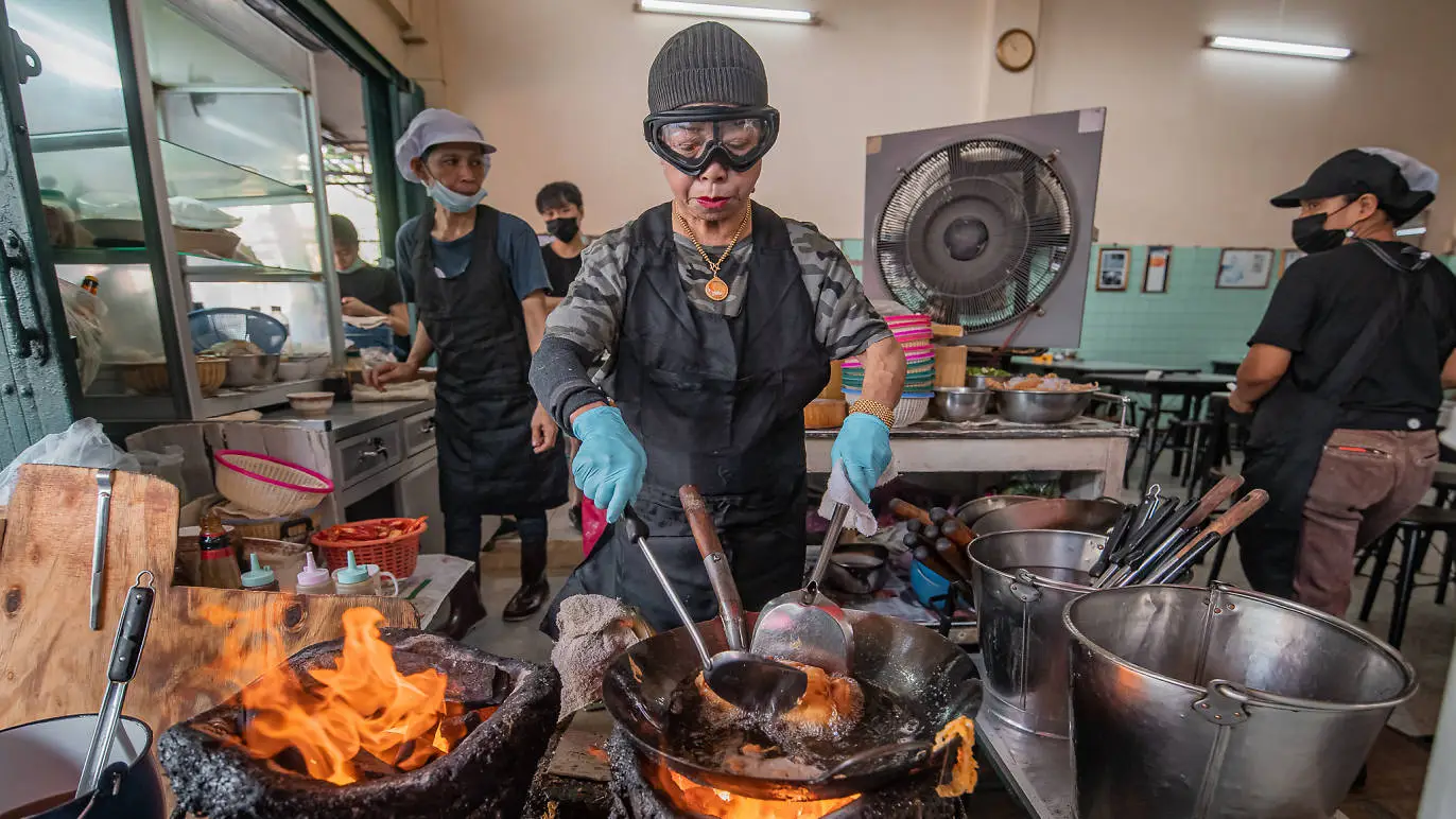Jay Fai preparing iconic crab omelette at Bangkok Street Food MICHELIN Restaurants with intense focus