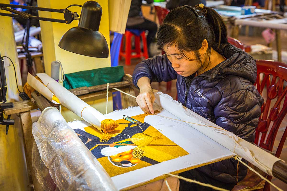 Vietnamese artisan hand embroidering textile, authentic what to buy in hanoi