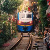 Train passing through Hanoi train street crowded with visitors
