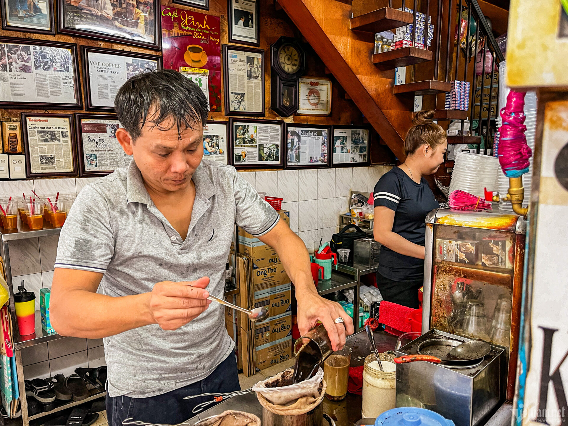 A local barista skillfully pouring traditional Vietnamese filter coffee in a cozy, vintage-styled cafe, a must-see stop on a Ho Chi Minh City tour