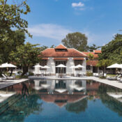 Amantaka resort at dusk featuring colonial-style architecture, reflecting pool, and tranquil garden setting in Luang Prabang