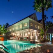 Outdoor swimming pool at Homm Souvannaphoum Luang Prabang with sun loungers, poolside bar, and colonial-style architecture